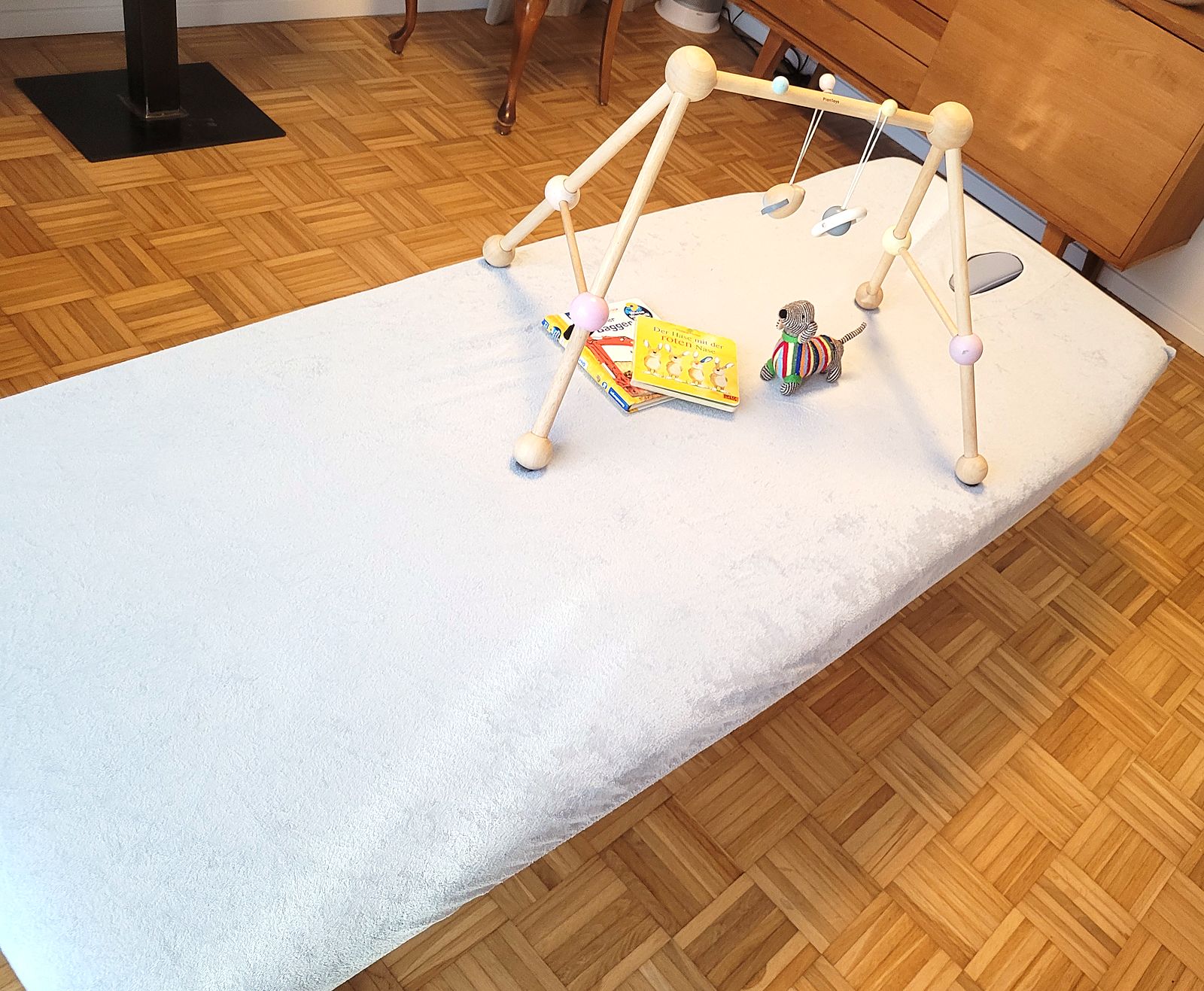 Behandlungsliege mit Baby-Spielbogen in der Praxis in Wachenhausen